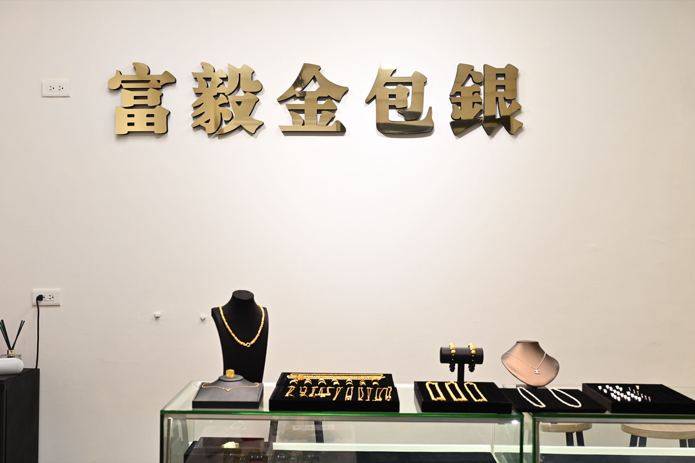 富毅金包銀淡水門市店內,品牌牆與展示櫃