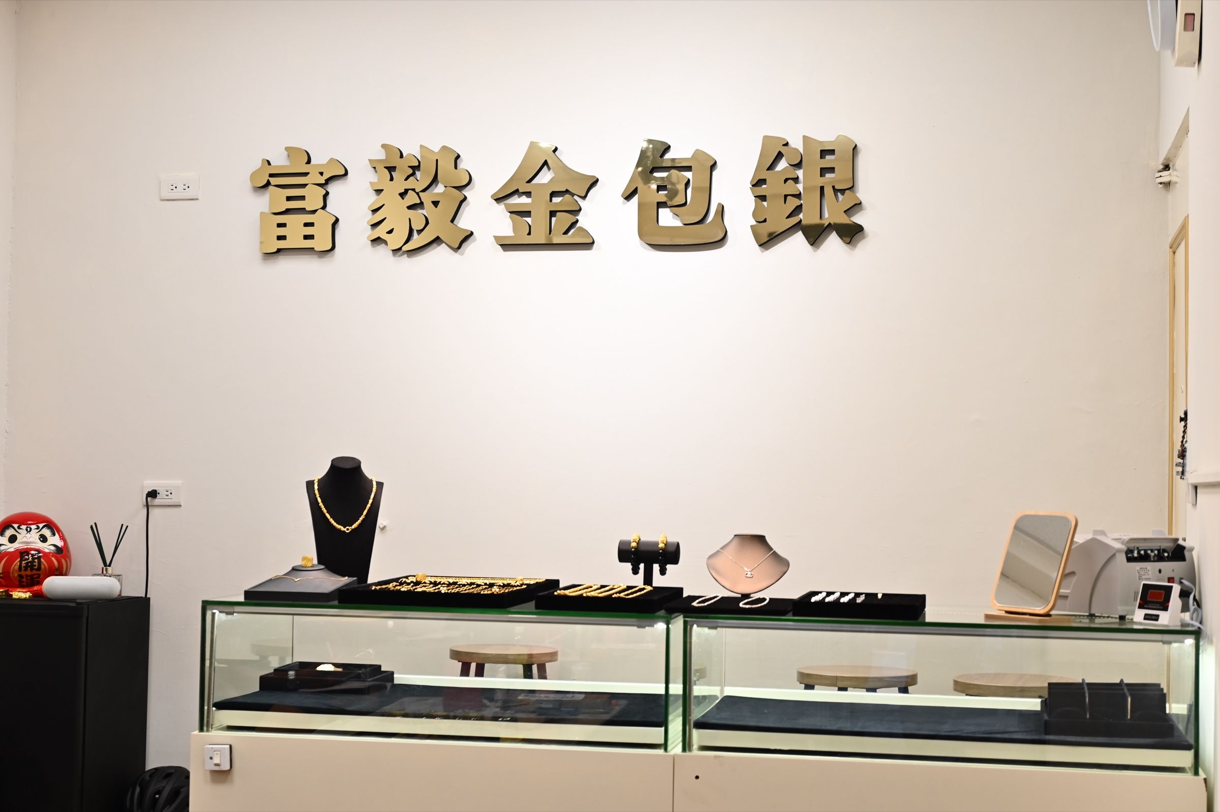 富毅金包銀淡水門市店內，展示櫃與品牌牆